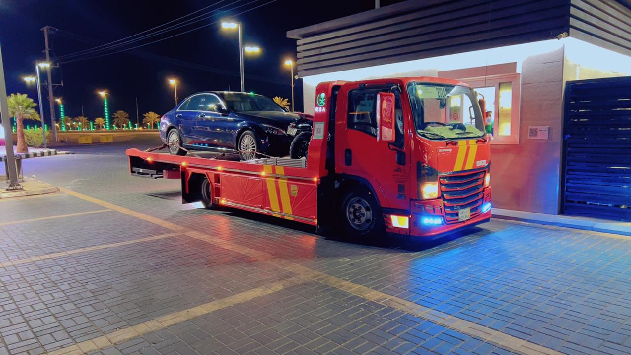 سطحة الرياض تعمل ليلاً مع إضاءة LED تنقل سيارة سوداء - خدمة طوارئ 24 ساعة في الرياض